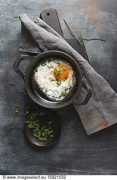 Fried egg with chives in cast iron pan