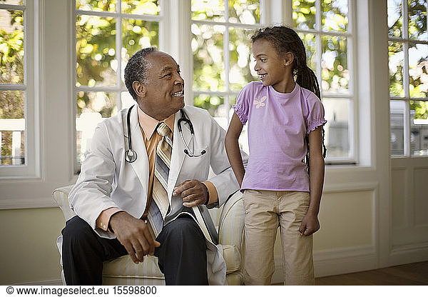 Friendly senior doctor smiling at a young patient.