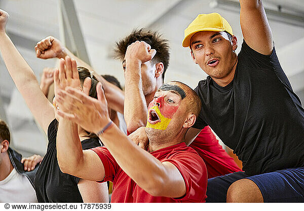 Friends cheering together at sports event in stadium