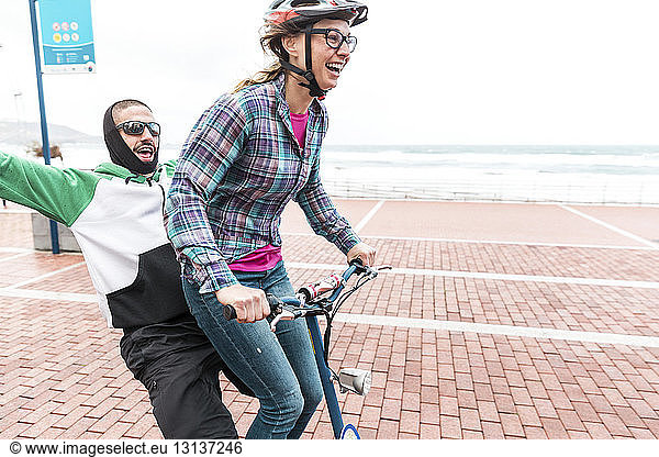 Friends enjoying bicycle ride on promenade