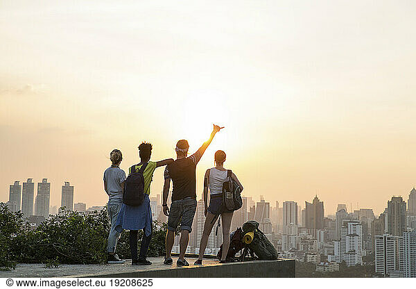 Friends enjoying sunset view from rooftop