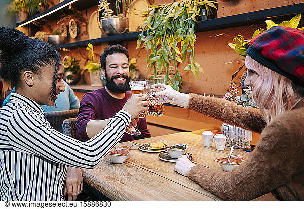 Friends having drinks in a restaurant  clinking glasses