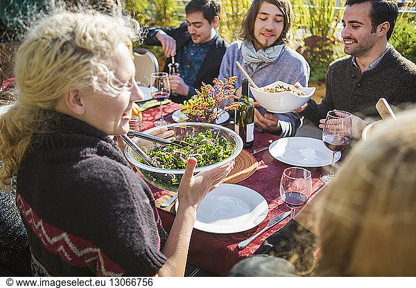 Friends having meal at outdoor table during garden party