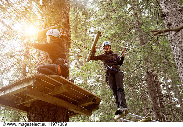 Friends in forest using high rope course