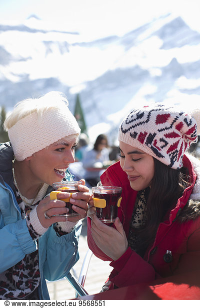 Friends in warm clothing drinking tea outdoors