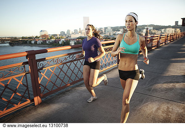 Friends jogging on bridge