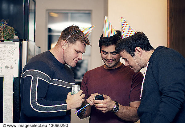 Friends looking at mobile phone during party at home