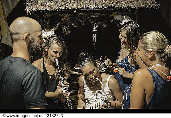Friends looking at women playing wind instruments in tourist resort