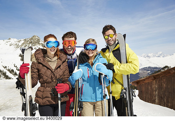 Friends on mountain top holding skis together
