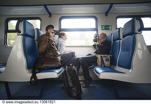 Friends photographing while travelling in train