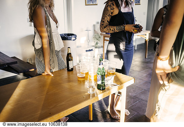 Friends playing beer pong at home
