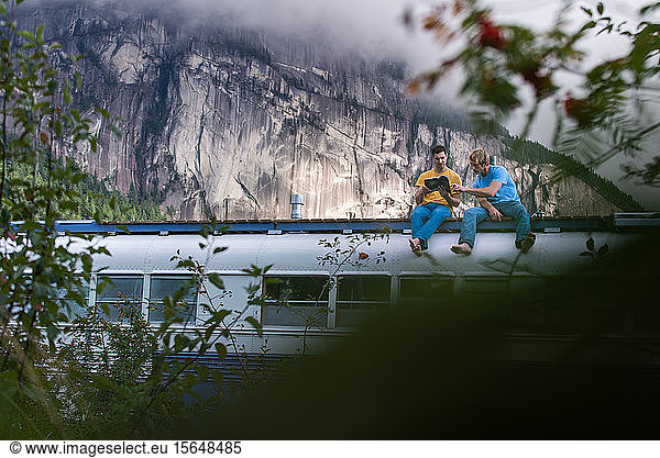 Friends reading book on roof of motorhome  Squamish  British Columbia  Canada