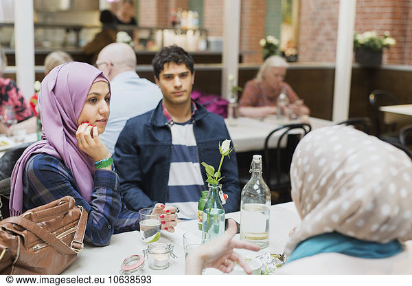 Friends sitting at table in railroad station cafe