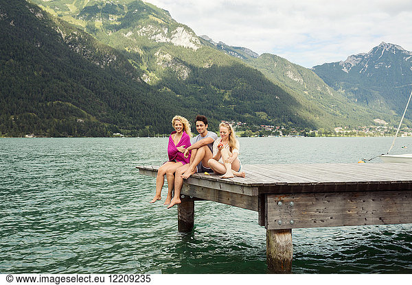 Friends sitting together on edge of pier  Innsbruck  Tirol  Austria  Europe