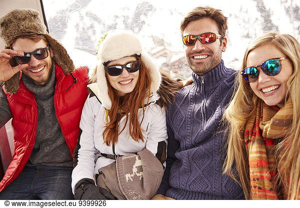 Friends smiling together on ski lift