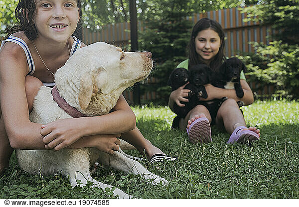 Friends spending leisure time with dogs in back yard
