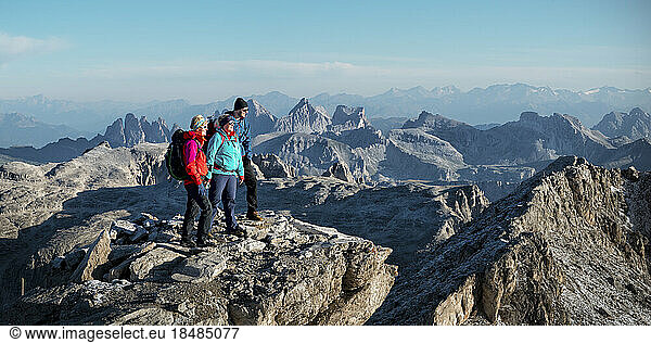 Friends standing at Piz Boe mountain on sunny day  Dolomites  Italy