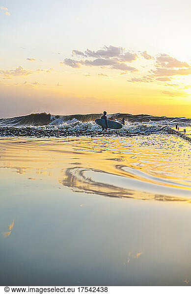 Friends surfing together on Black Sea at sunset