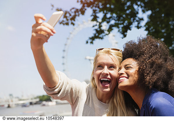 Friends taking selfie with London Eye in background  London  United Kingdom
