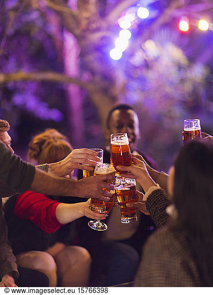 Friends toasting beer glasses at party