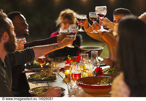 Friends toasting wine glasses at dinner garden party