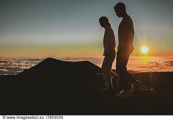 Friends walk at sunset on top of Mauna Kea