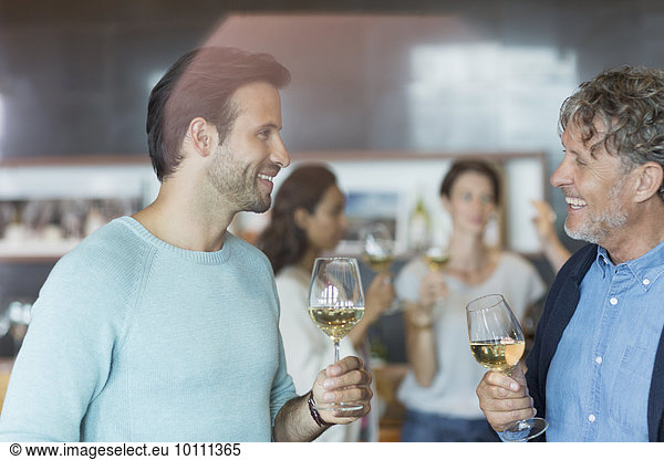 Friends wine tasting and talking in winery tasting room