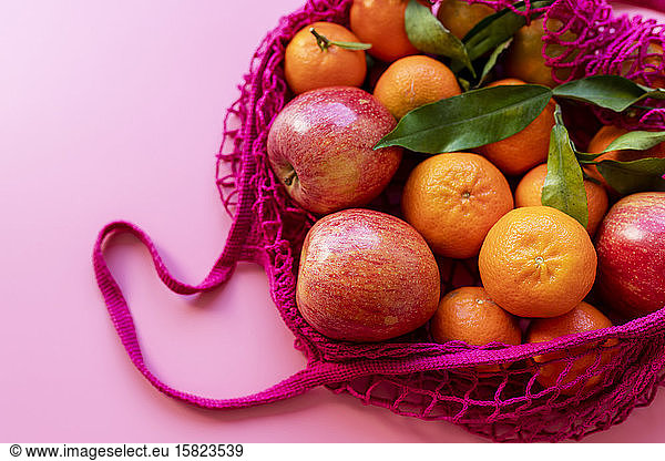Frische Clementinen und Äpfel in umweltfreundlichem  wiederverwendbarem Netzbeutel