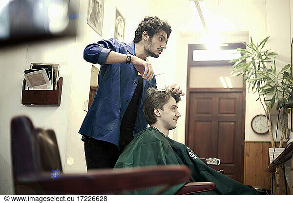 Friseur schneidet Haare eines männlichen Kunden