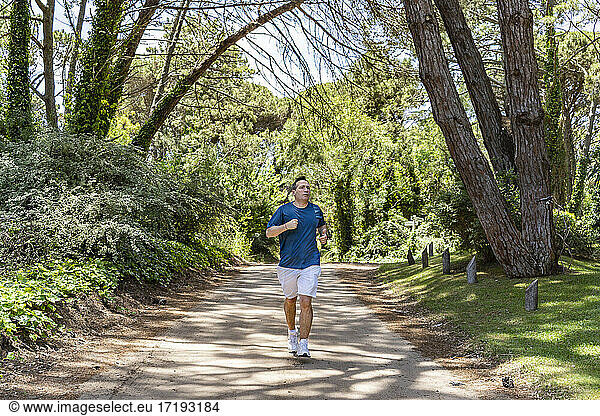 Front View of a man running outdoors training for Marathon