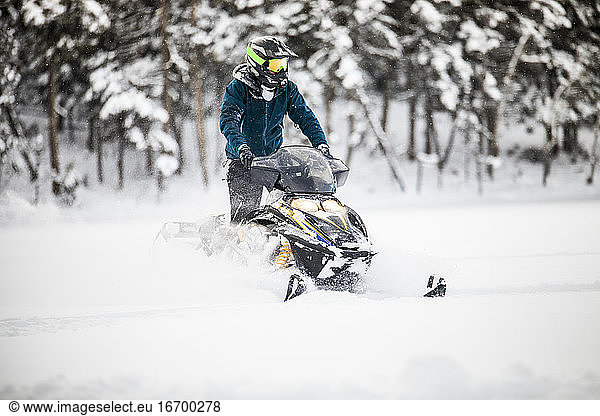 Front view of aggressive confident operator on snowmobile