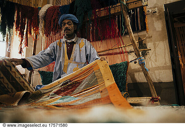 Front view of an Arab vendor of handmade carpets.