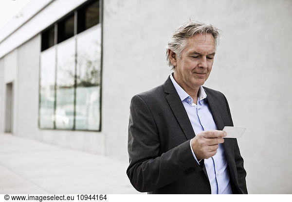 Front view of senior businessman reading card