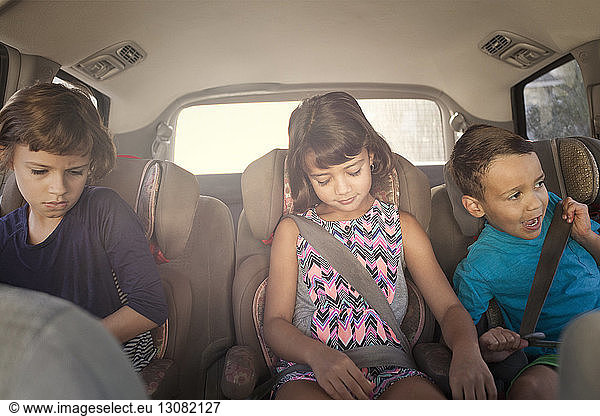 Front view of siblings sitting in car