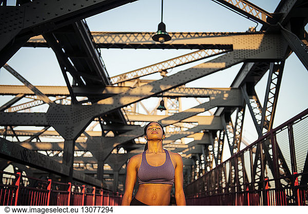 Front view of woman relaxing while standing on bridge