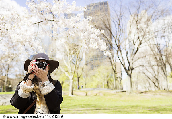 Front view of woman with camera standing at Central Park