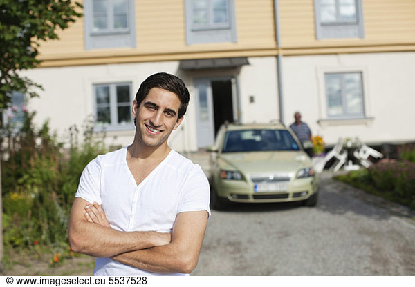 Front view of young man with person in background