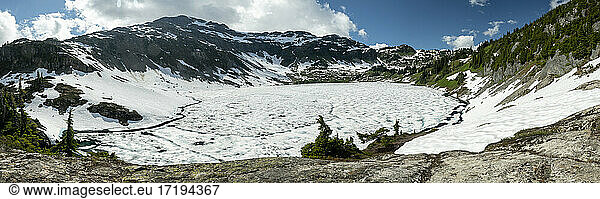 Frozen lake and snowy mountains in spring on outdoor hike