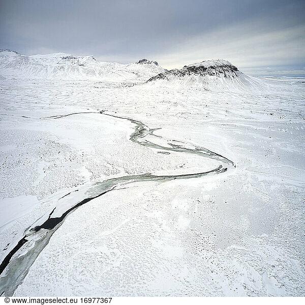 Frozen river in mountainous valley in winter