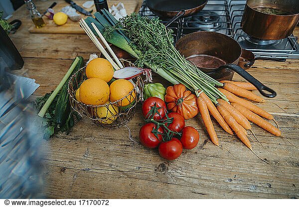 Fruits and vegetables by kitchen utensil on kitchen island