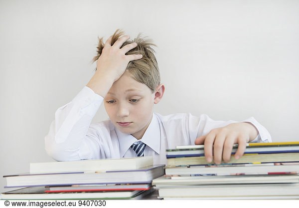 Frustrated boy with stack of books  close up