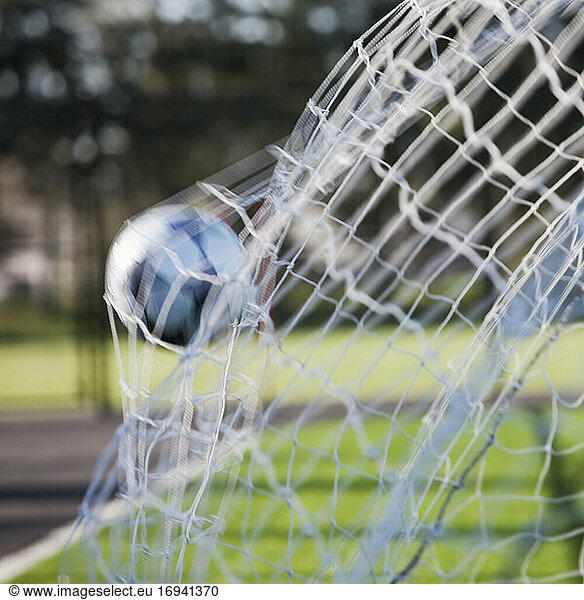 Fußball  der auf die Rückseite eines Fußballnetzes trifft.