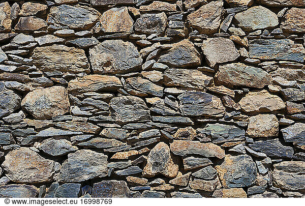Full frame shot of stone wall on sunny day