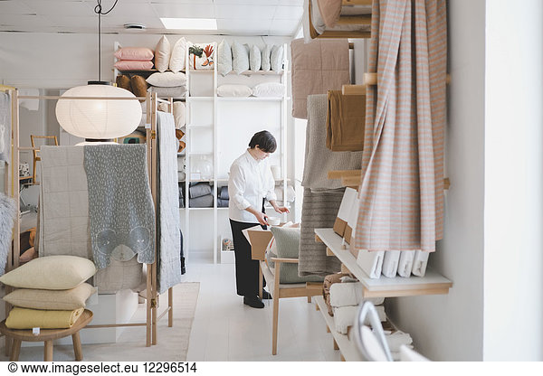 Full length of female interior designer working in workshop
