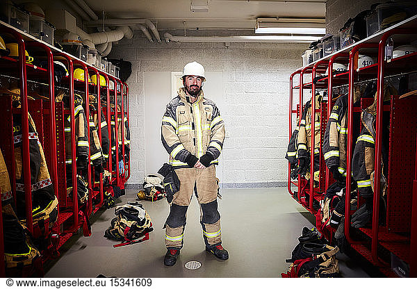 Full length of male firefighter standing in locker room at fire station
