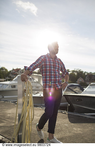 Full length of man standing on pier at harbor
