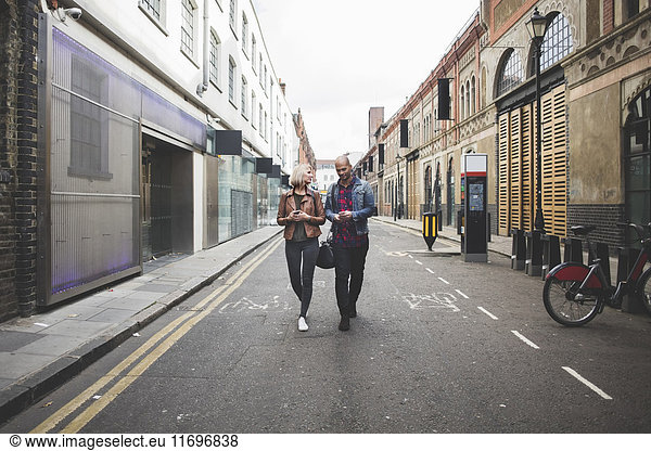 Full length of multi-ethnic couple walking on city street