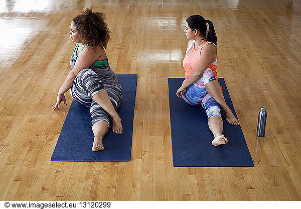 Full length of plus size females exercising in gym