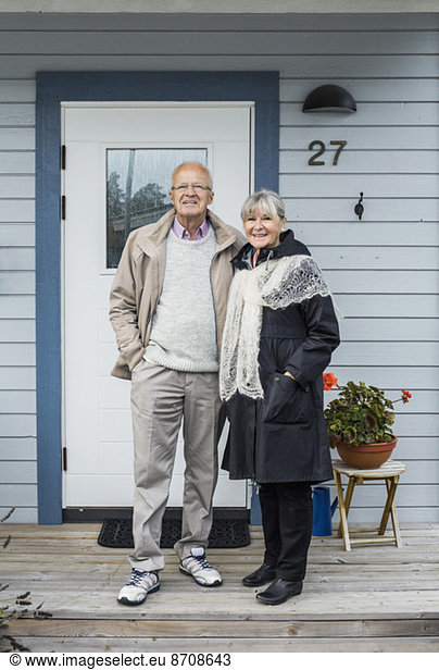 Full length of senior couple standing on porch