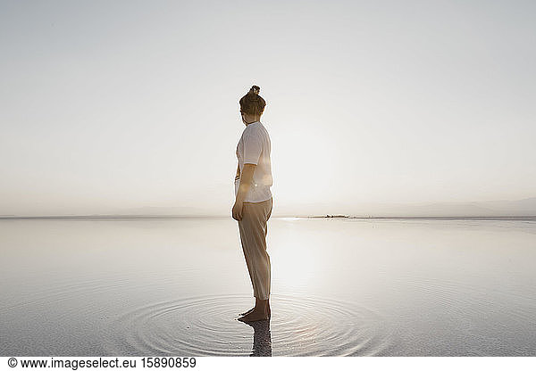 Full length of woman standing at Lake Karum in Danakil Depression against sky  Ethiopia  Afar